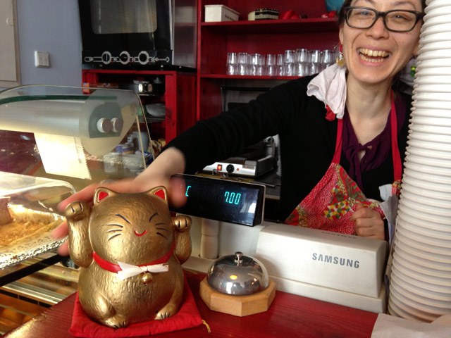 Yuki with lucky cat figurine at cash register