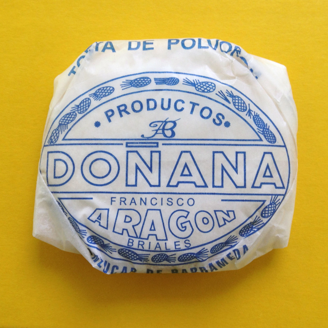 Cookie wrapped in white waxed paper with blue Spanish lettering