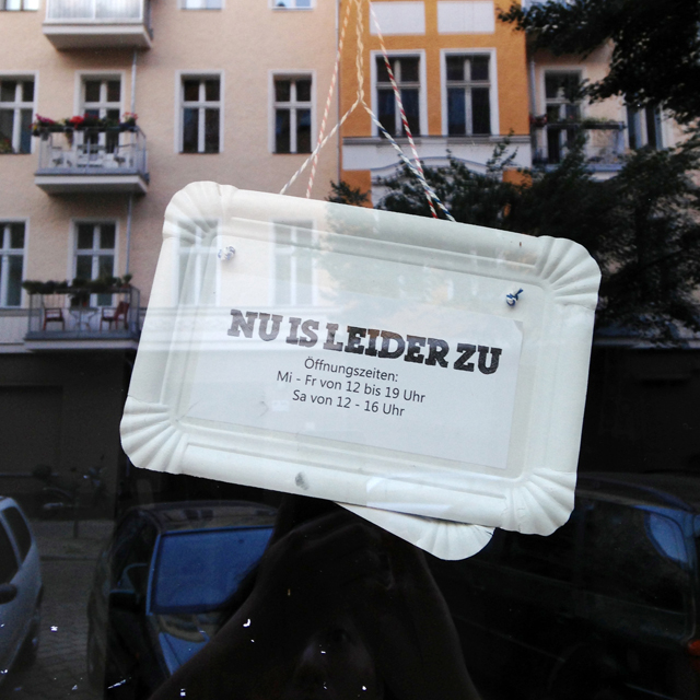 Sign in window made of paper take-out tray reading "Nu is leider zu"