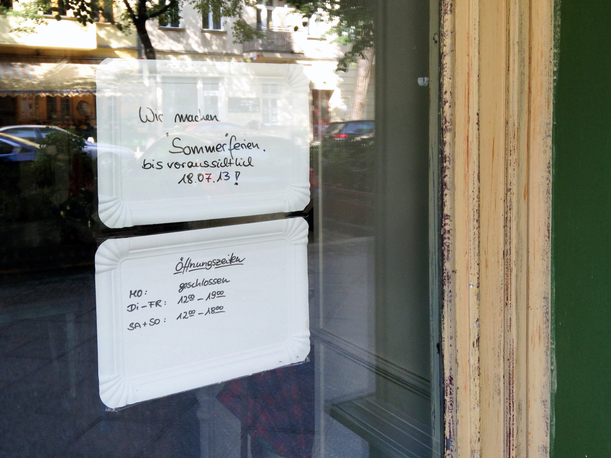 Two signs in window made of paper take-out tray 