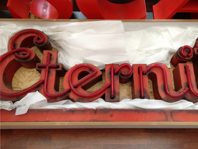 Neon letters "Eterni" in a tissue-lined box 