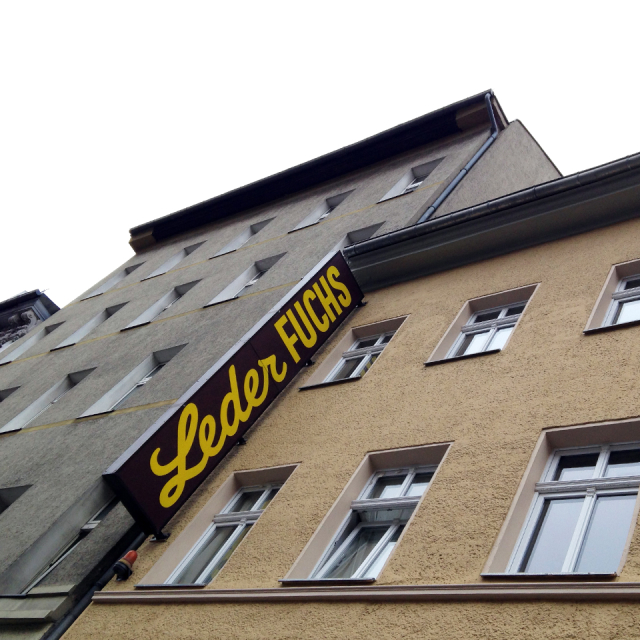 Building facades with sign reading "Leder Fuchs"