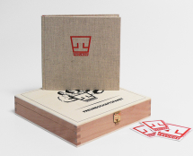 Small square book, with "T" logo, standing on its wooden box
